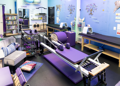 Private Pilates session with instructor guiding client through mat-based stretching exercise