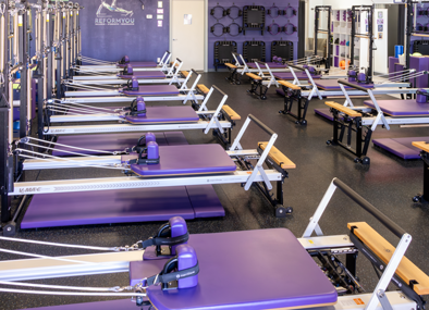 Pilates reformer studio with neatly arranged machines and modern workout space